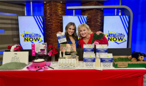 Two women showcase skincare products on a TV show set.