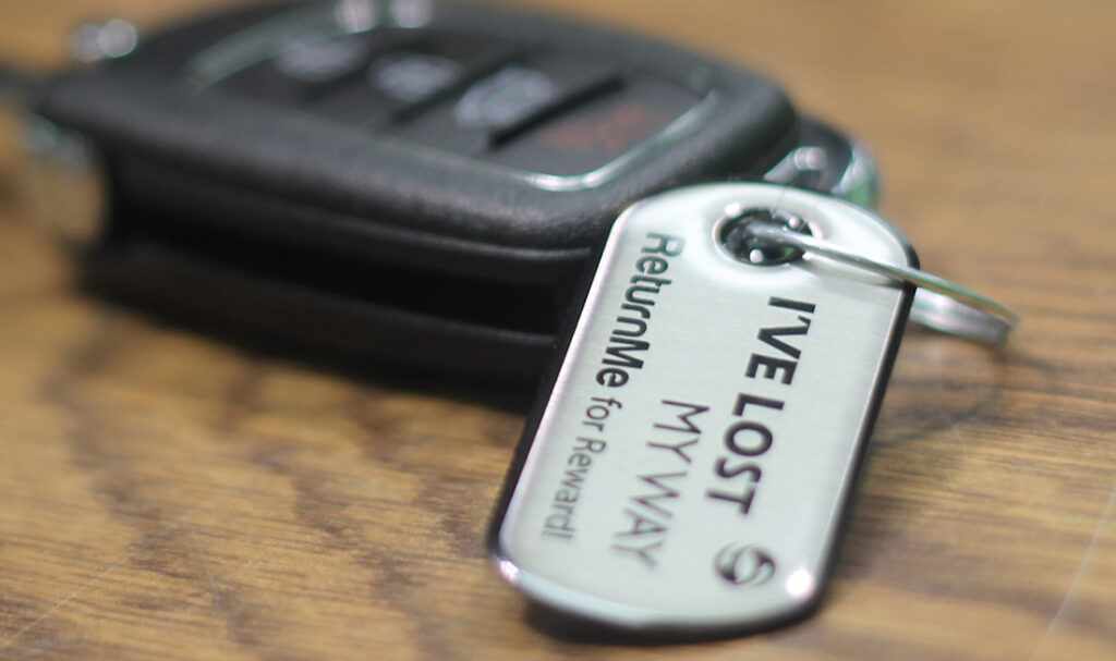 Close-up of a car key with a lost pet tag attached.
